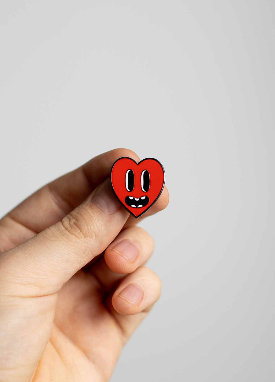 Hand holding Heart enamel pin
